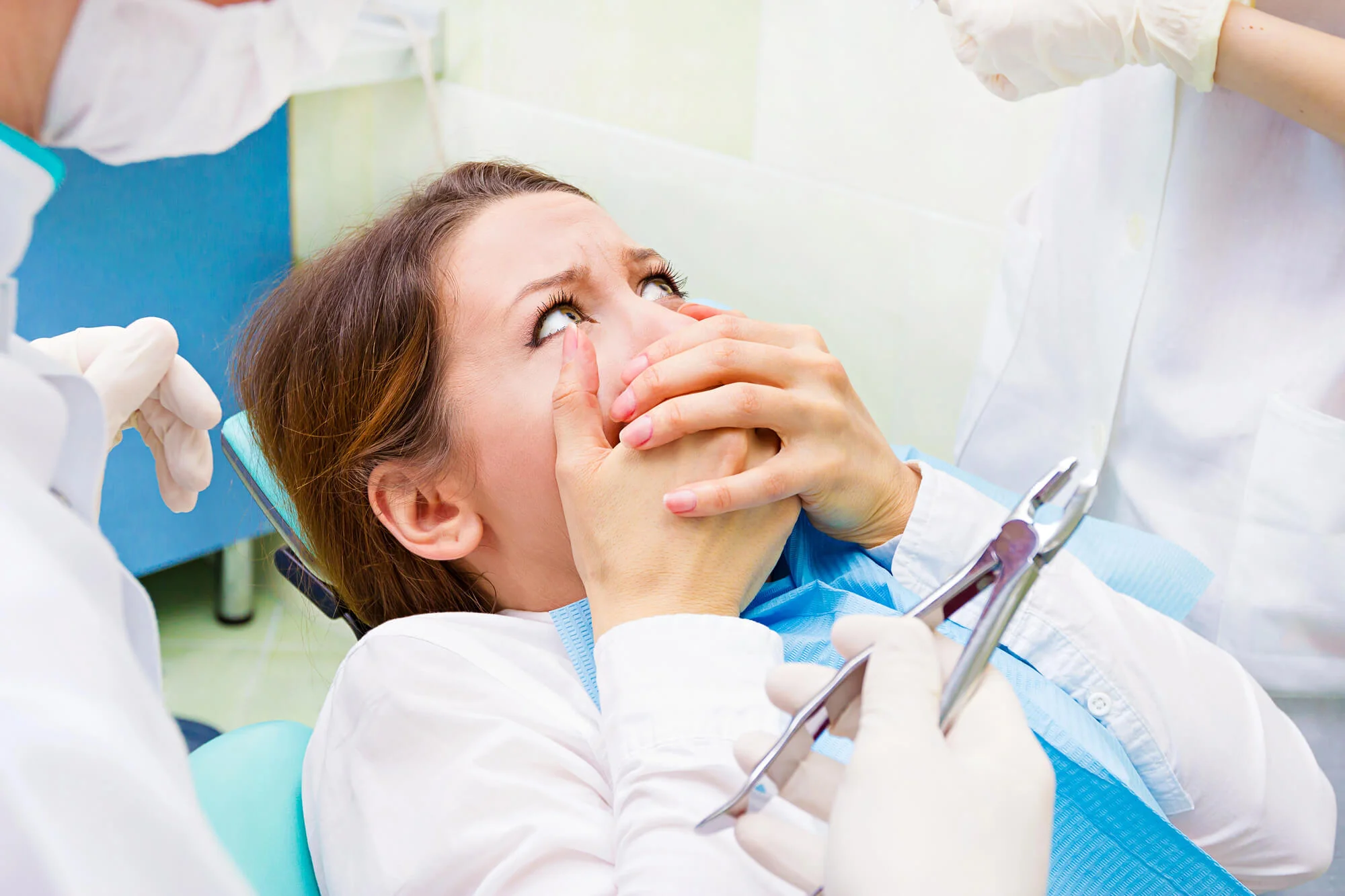 Patient visibly frightened during dental procedure due to dental anxiety in NYC.