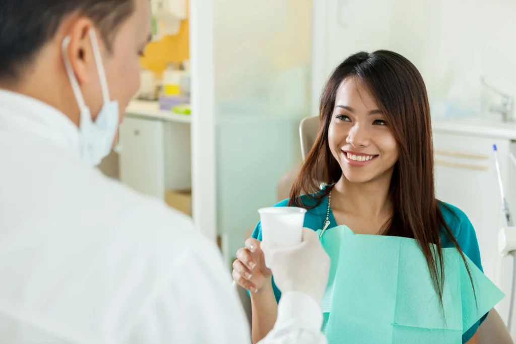 Happy patient with dentist during pain free dentistry in New York City.